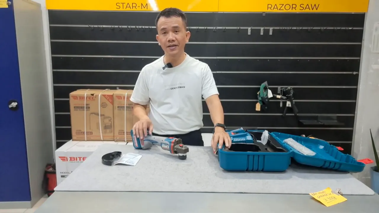 Máy mài góc Total TAGLI4128102 gắn pin 42V trên bàn cùng hộp đựng mở, ánh sáng rõ