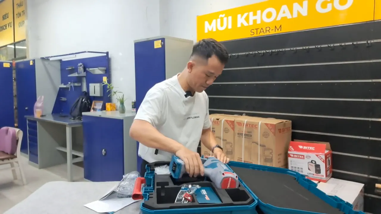 Người kiểm tra và đặt máy bắn đinh Total TCNLI420602 vào vali, hiển thị thân máy và phụ kiện