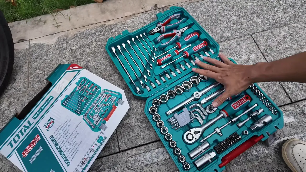 Bộ công cụ Total mở trên nền đá, tay chạm vào các chi tiết