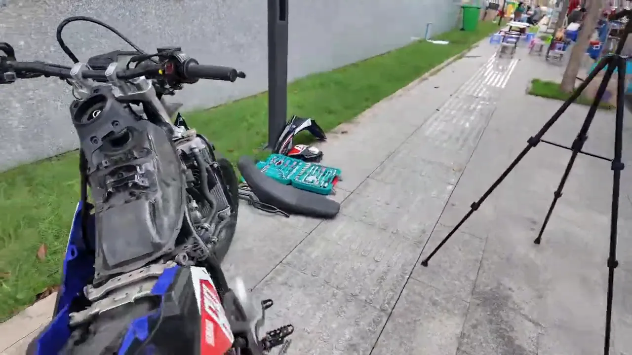 xe máy đã tháo dàn áo với bộ đồ nghề và tripod bên cạnh