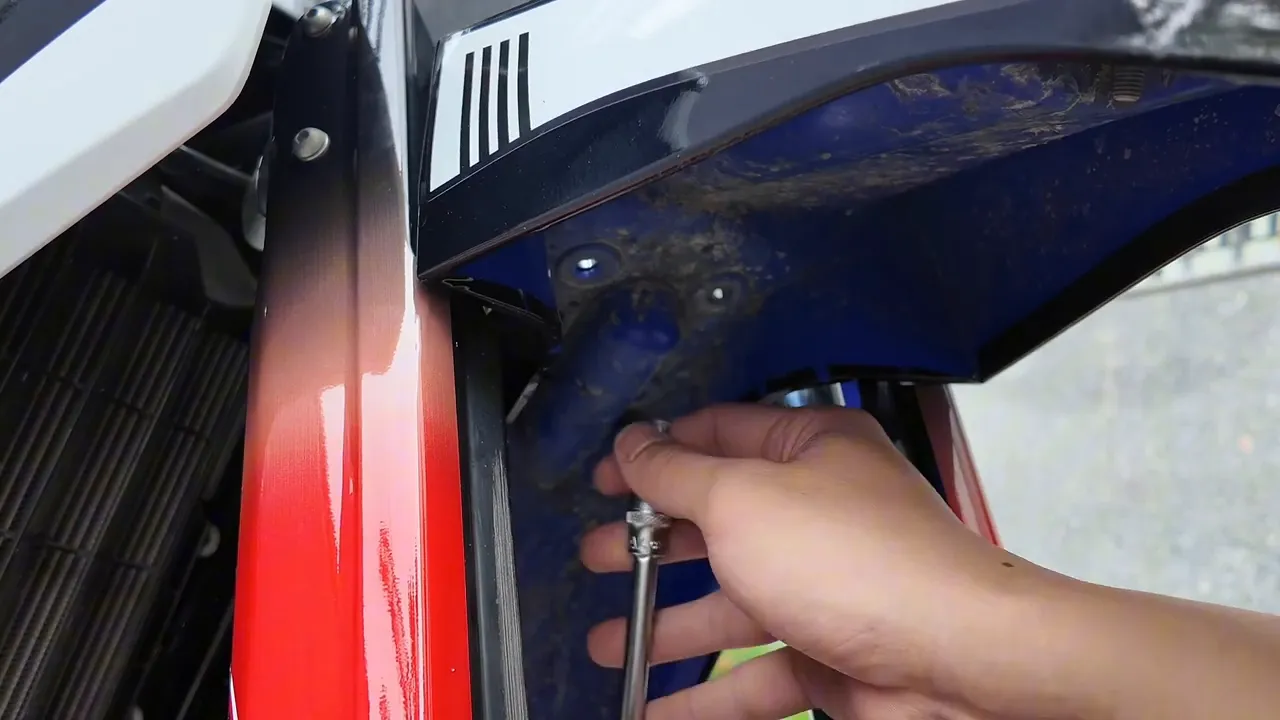 Thanh nối kèm tuýp 10 mm đang tiếp cận con ốc sâu bên trong dè xe