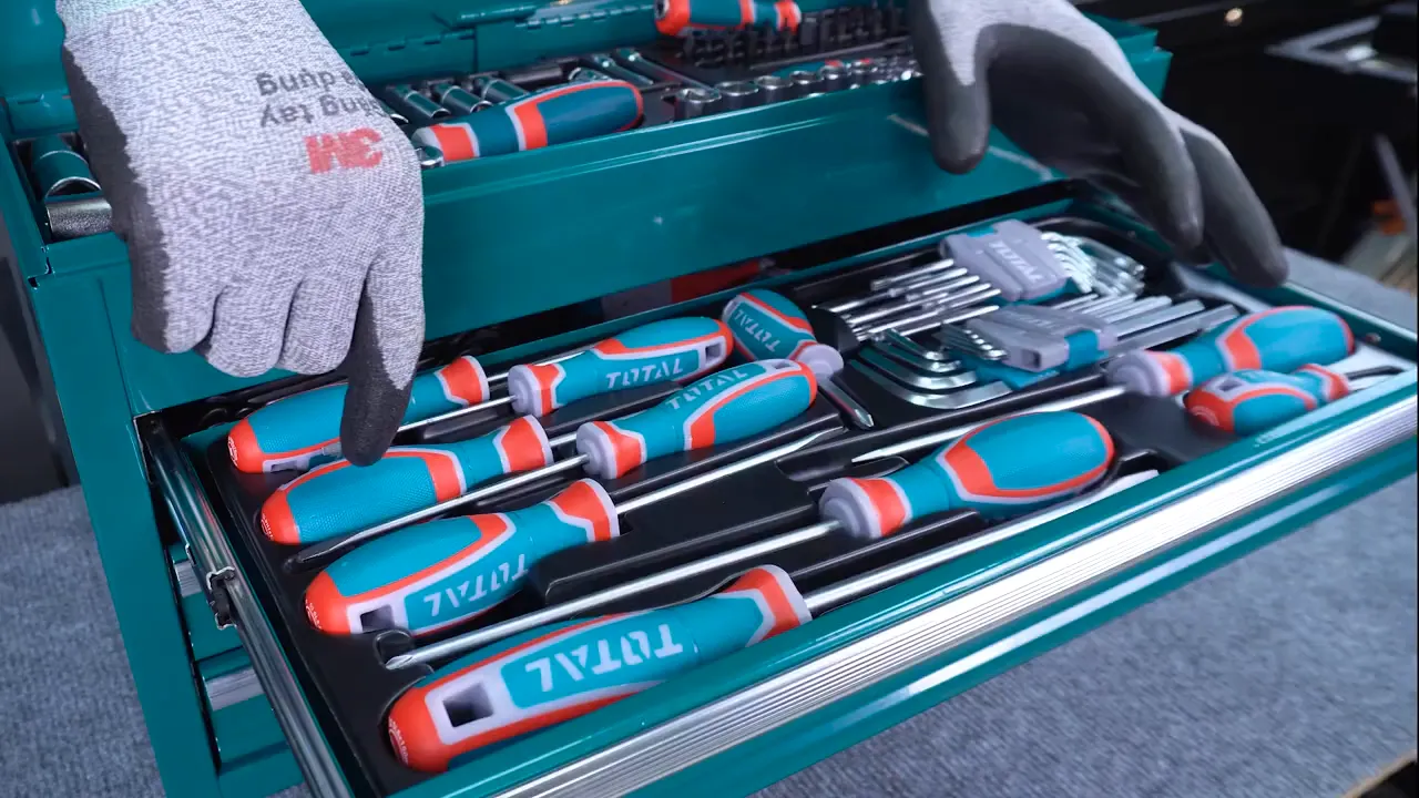 Khay ngăn giữa chứa bộ tua vít Total và bộ lục giác nhỏ, tay có găng chỉ vào dụng cụ