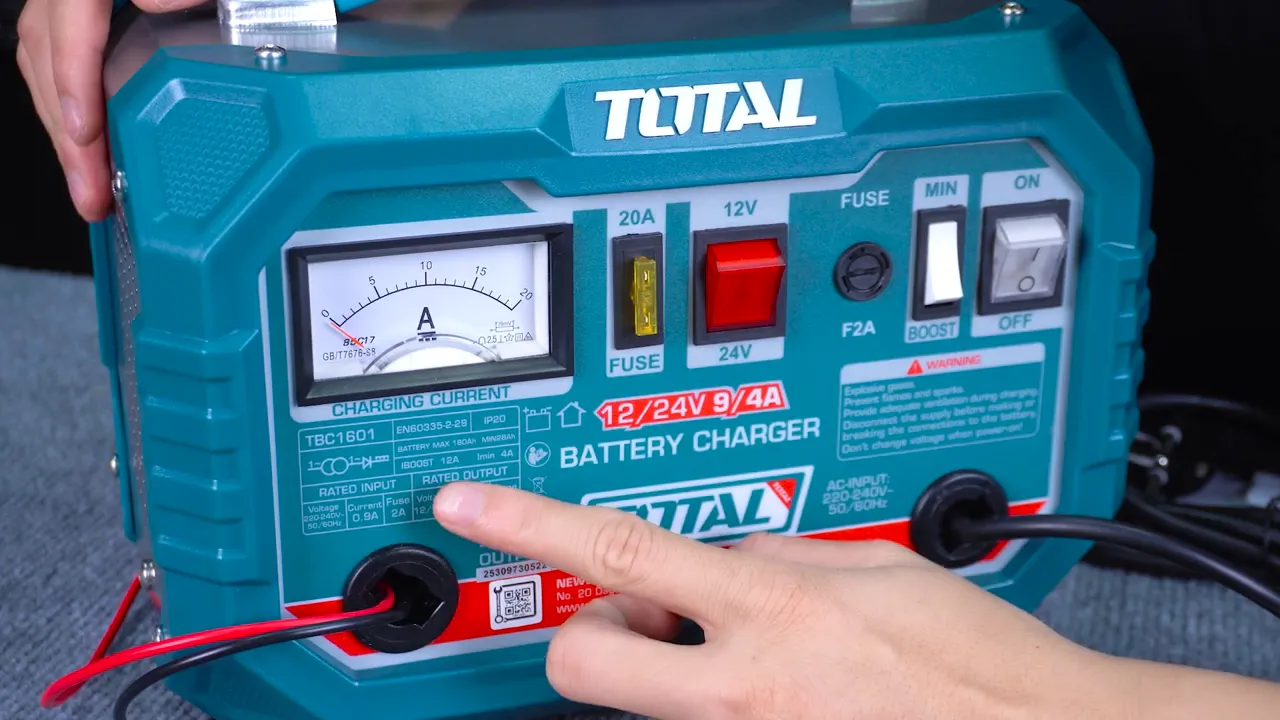 Chi tiết nhãn 12/24V và thông số đầu ra trên Total TBC1601, ngón tay chỉ vào thông số