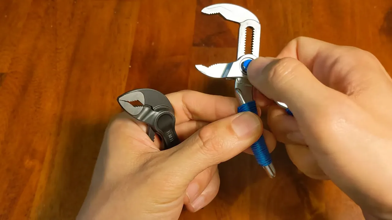 Ngón cái đang đặt lên chốt/pivot của kìm, thể hiện cơ chế khóa/điều chỉnh với rãnh trượt rõ ràng