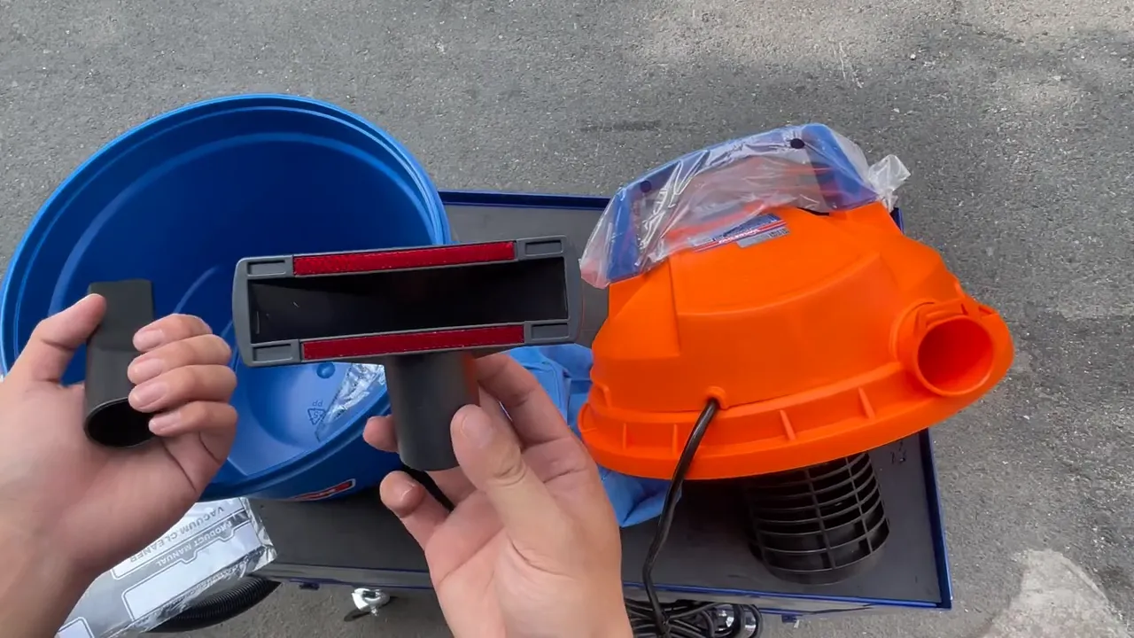 Đầu hút thảm và đầu khe của máy hút WADFOW được cầm trên nền thùng và nắp máy