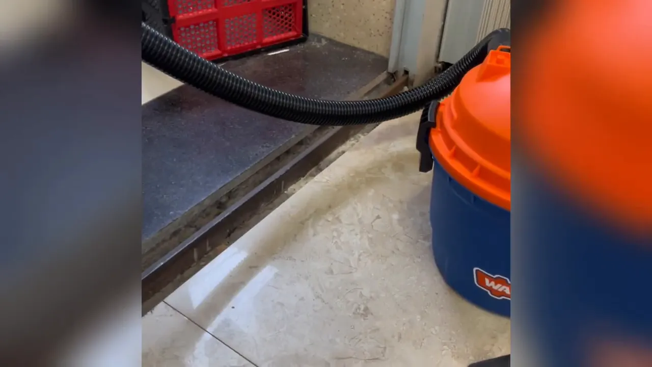 Ống hút mềm uốn cong nối từ nắp máy WADFOW sang khu vực cần vệ sinh.