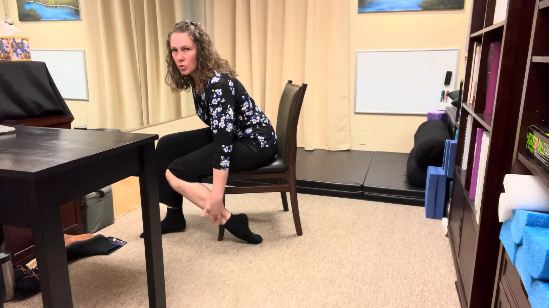 Demonstrating the chair-assisted stretch for the top of the foot.