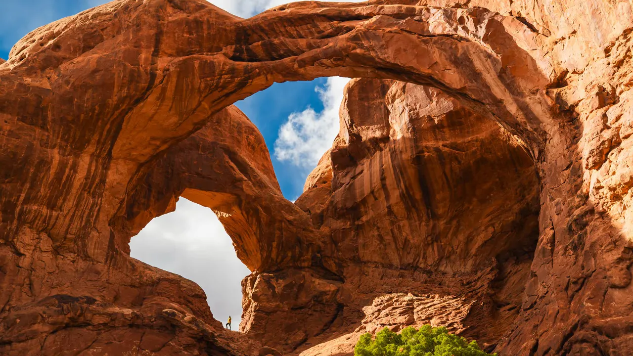 Double Arch at Arches National Park showing the twin sandstone spans with a small person for scale.