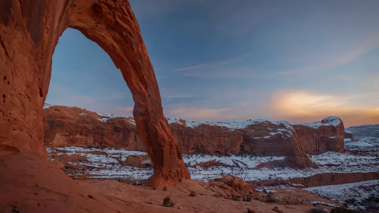 Corona Arch at dusk with canyon and clear sky