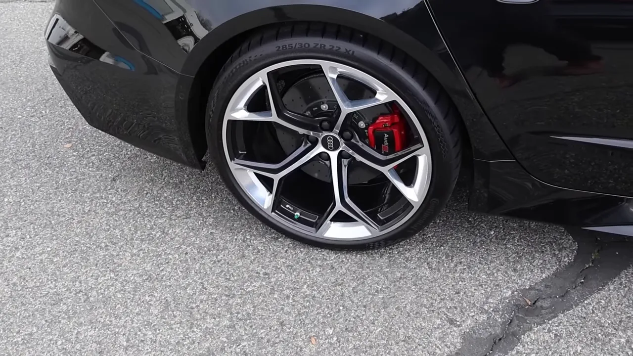 Audi RS7 rear wheel showing 285/30 ZR22 tire, alloy rim and red ceramic brake caliper