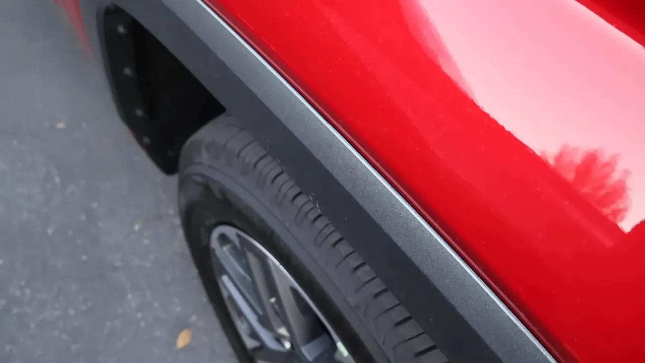 Red truck fender with metallic gray fender flare and partial wheel visible