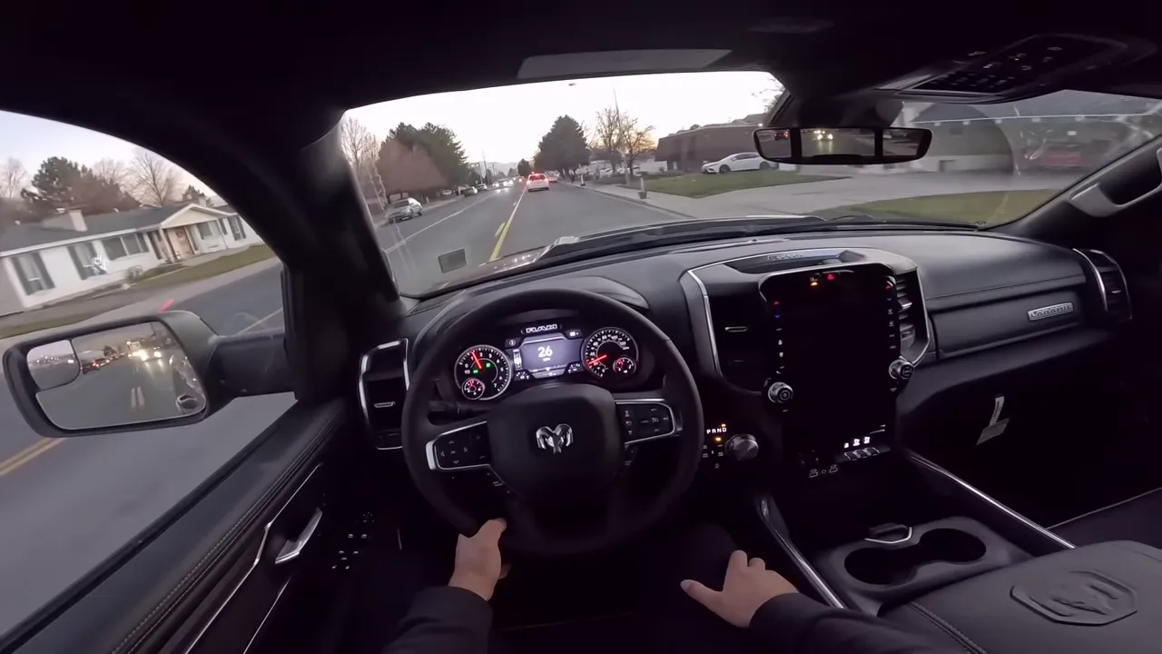 Clear driver's perspective in a Ram 1500 showing steering wheel, instrument cluster and road