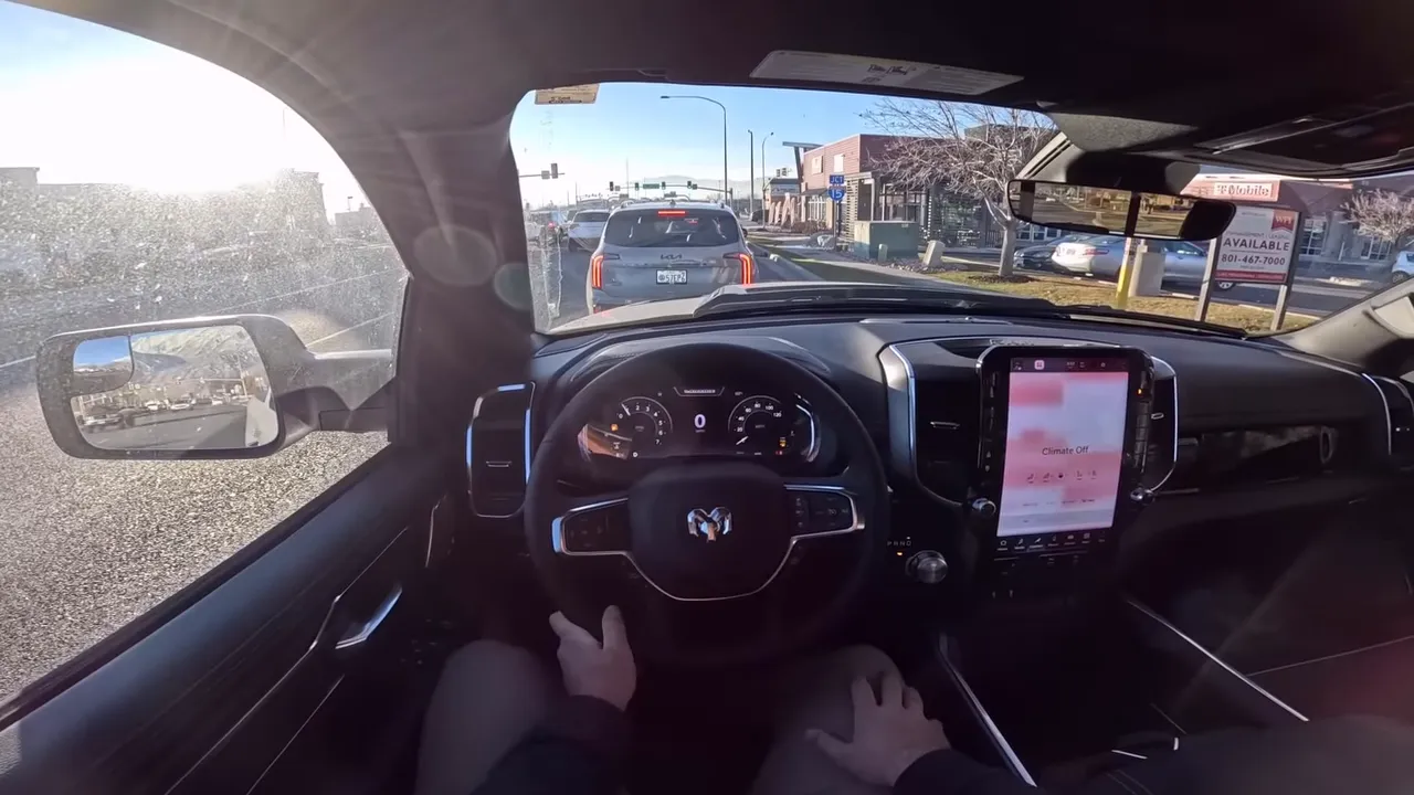 Ram 1500 interior stopped behind a car, clear instrument cluster and center touchscreen with dashboard at 0 mph