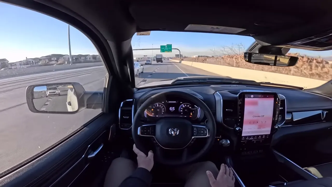 Driver view inside Ram 1500 showing steering wheel, instrument cluster reading 65 mph and center touchscreen, illustrating calm highway driving