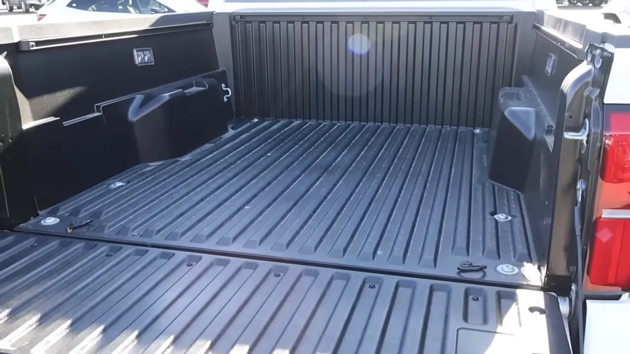 Wide shot of Tacoma truck bed with composite bed liner, tie-downs and tailgate down