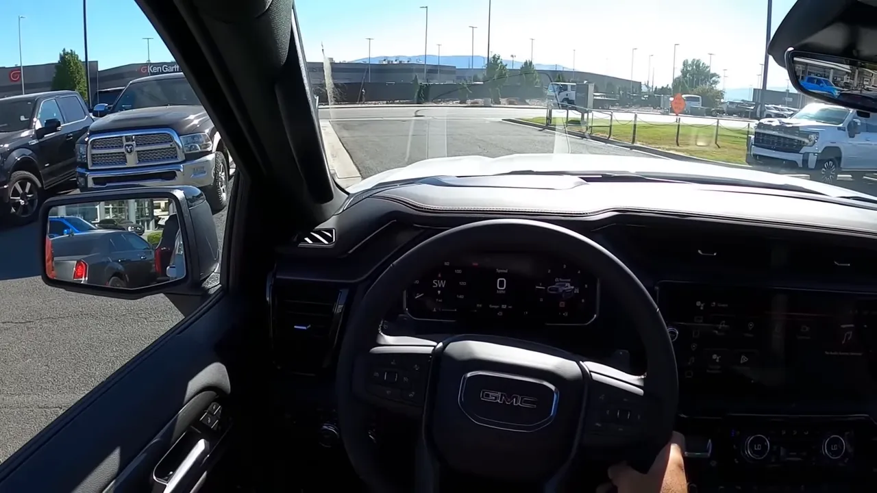 GMC Sierra AT4 behind-the-wheel view with digital instrument cluster, steering wheel and road ahead