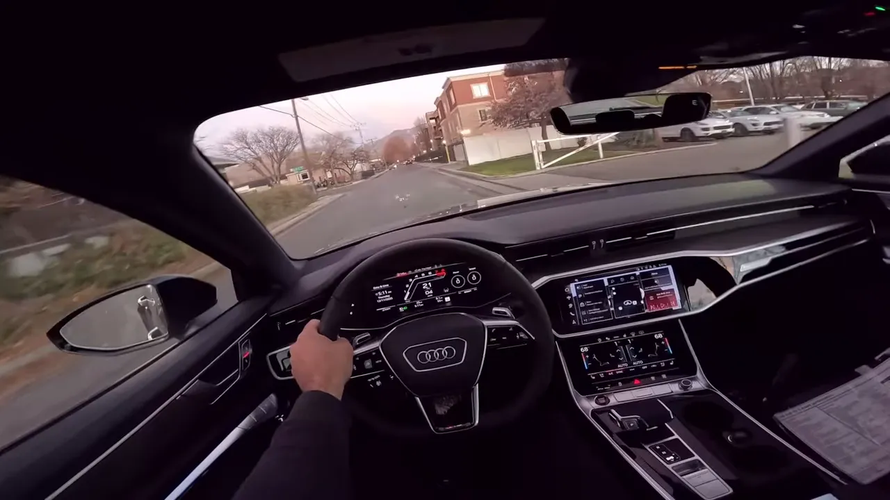 Forward interior shot of 2026 Audi RS6 Avant showing steering wheel, digital gauges, center touchscreen and road ahead