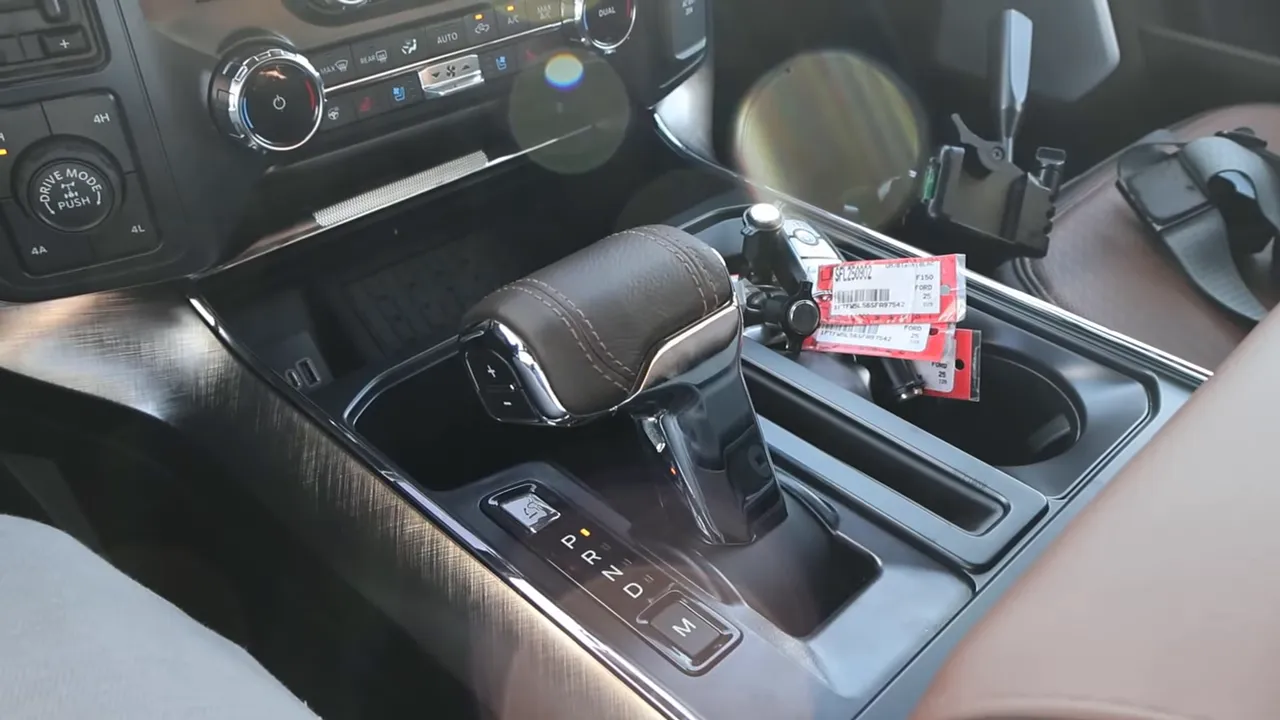 Center console and gear shifter of 2026 Ford F-150 King Ranch showing drive mode knob, climate controls and cupholders