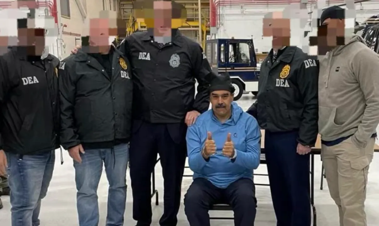 A seated, handcuffed man giving thumbs-up flanked by several law-enforcement officers wearing identifying jackets; faces blurred.
