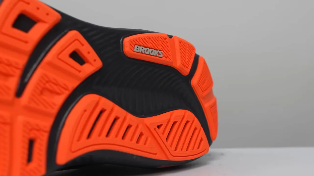 Brooks Ghost 17 outsole close-up showing orange rubber, BROOKS logo, and flex grooves