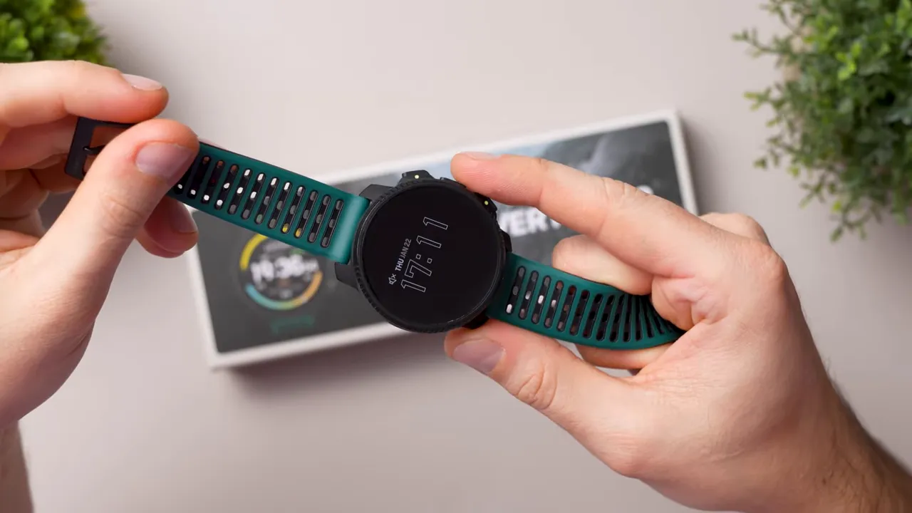 Suunto Vertical 2 smartwatch held flat showing the display with time and green ventilated strap