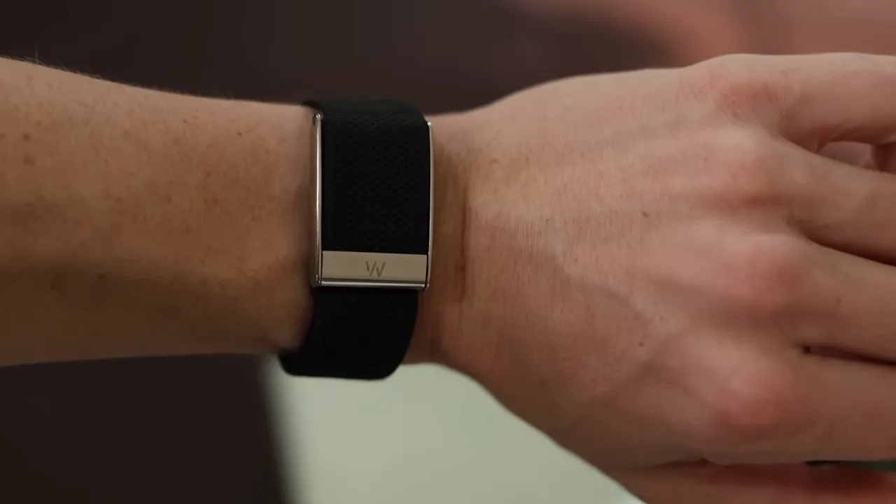 Close-up front view of a black WHOOP-style health band on a wrist, showing the clasp and strap texture.