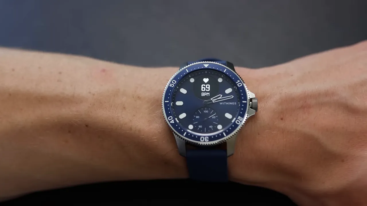 Withings ScanWatch Nova on a wrist with analog hands visible and a clear digital BPM readout (69 BPM) at the top of the dial.