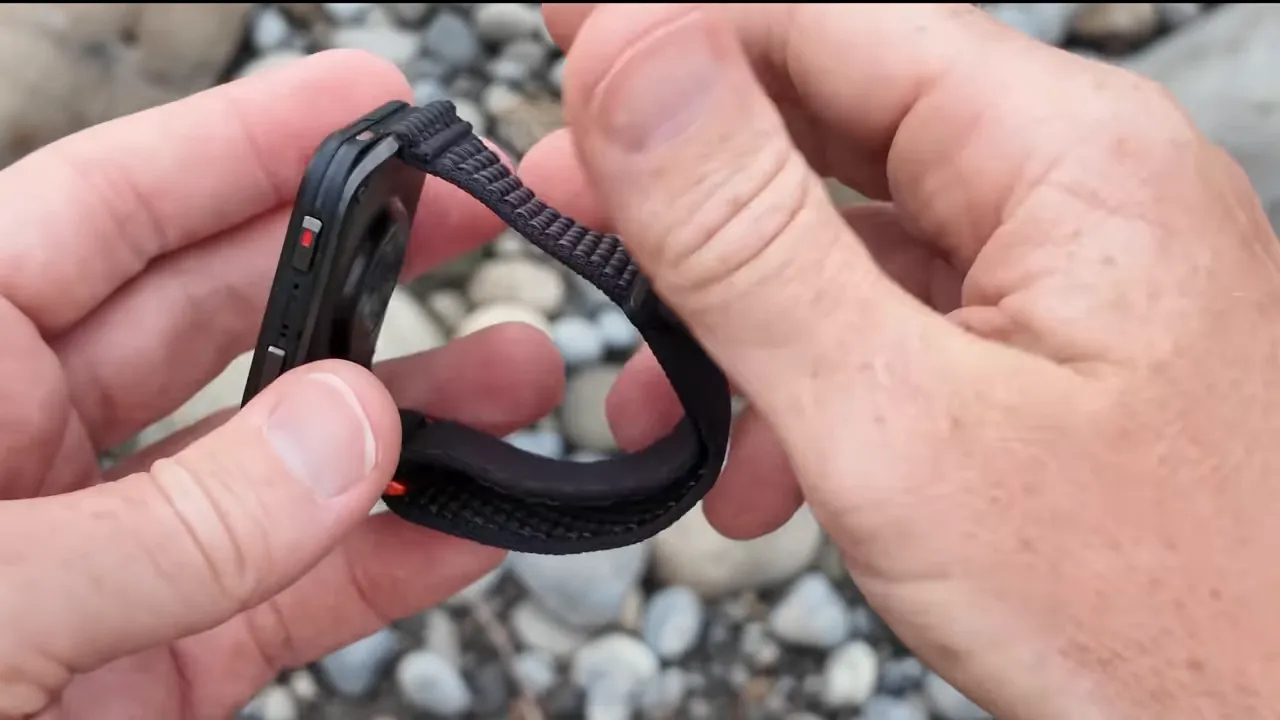 Garmin Venu X1 showing the default nylon Velcro strap folded to reveal fabric texture and padded underside.