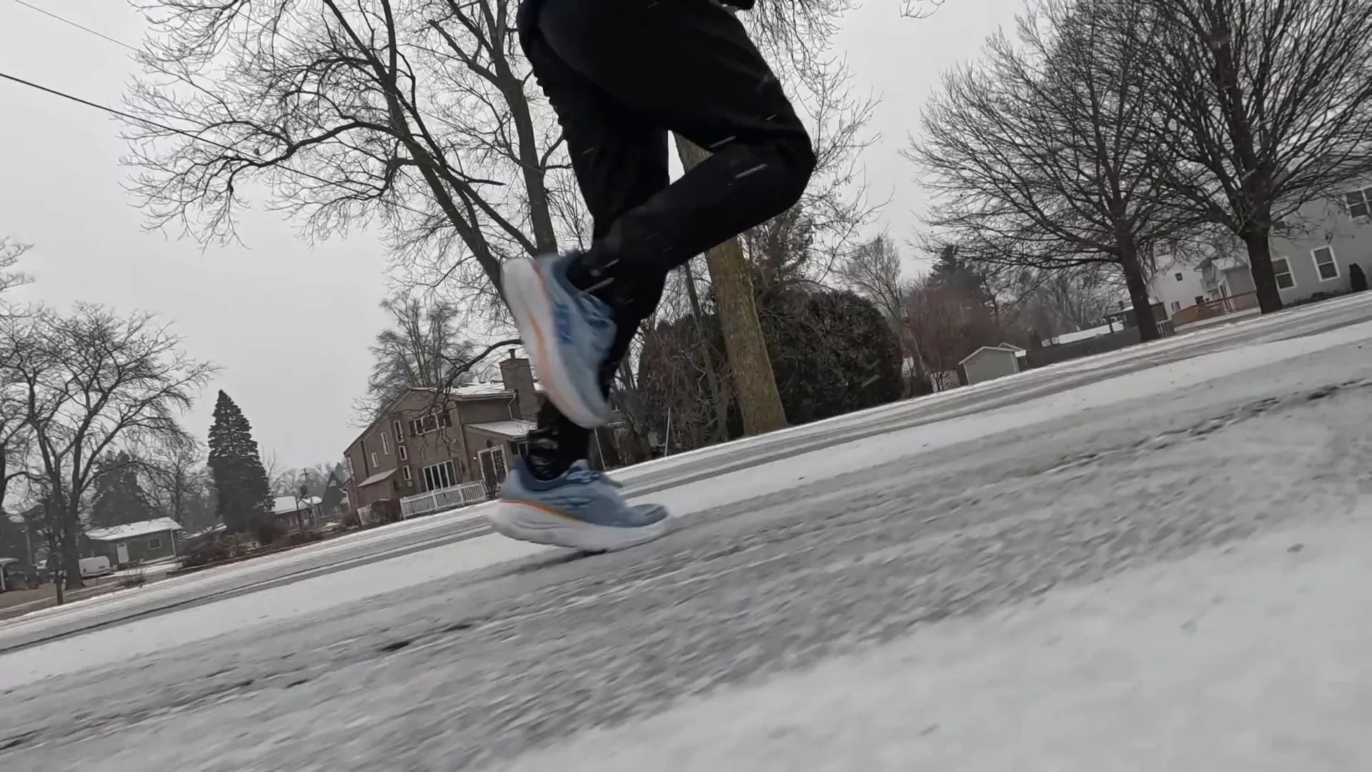 Person running wearing Hoka shoes, in a snowy environment