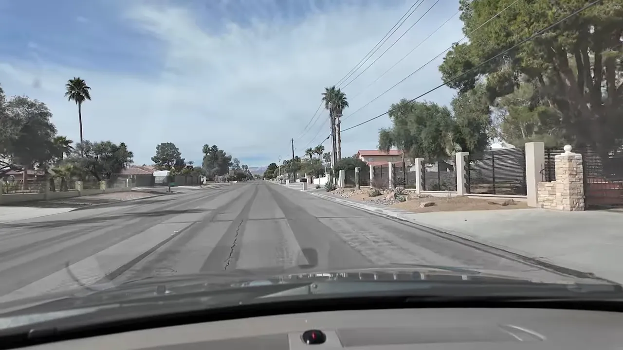Wide street in Las Vegas Section 10 lined with custom homes and perimeter fencing