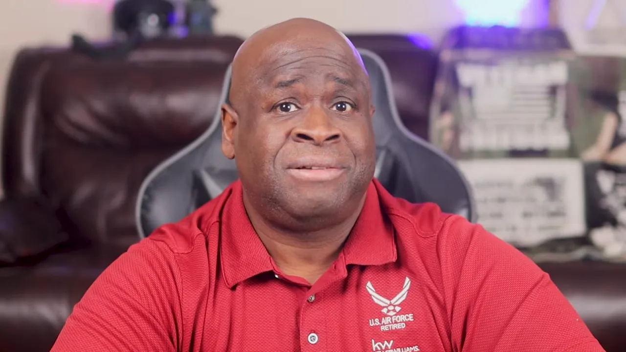 Centered shot of host in red polo speaking directly to camera with neutral expression