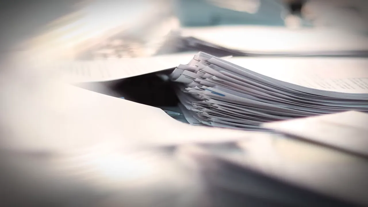 Close-up of stacked offer and sales documents, focused on paper edges