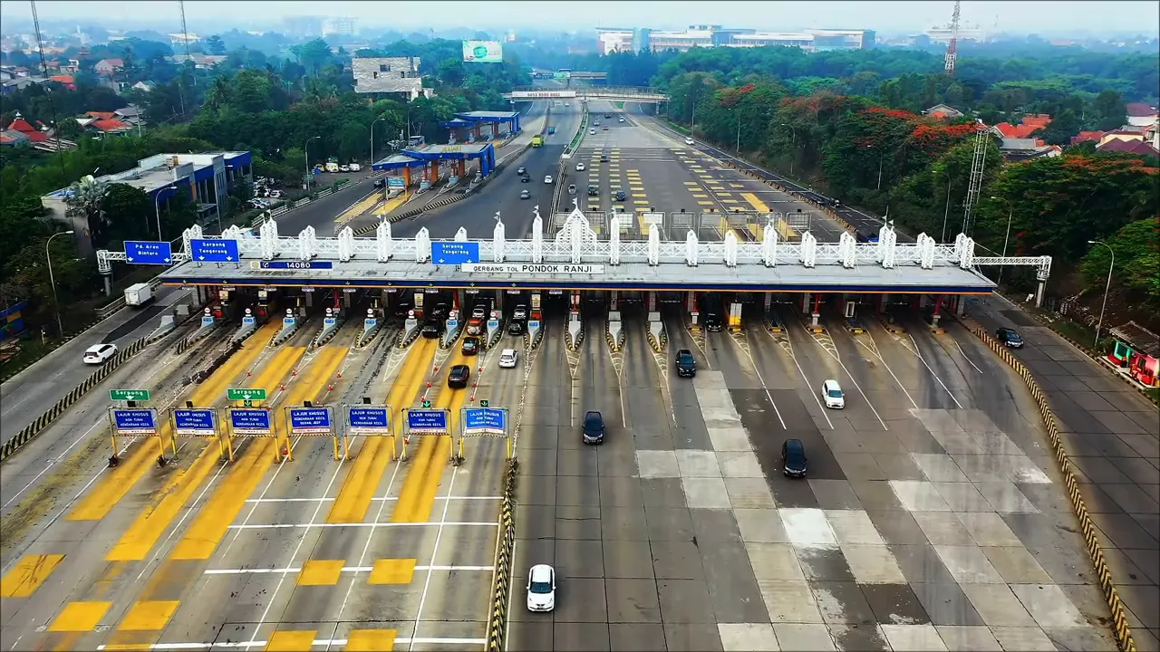 Aerial view of a multi-lane toll plaza with vehicles passing through several toll booths