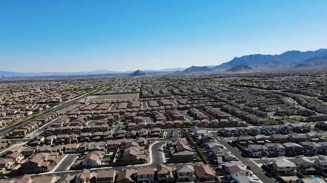 Wide aerial view of sprawling Las Vegas neighborhoods with distant mountains