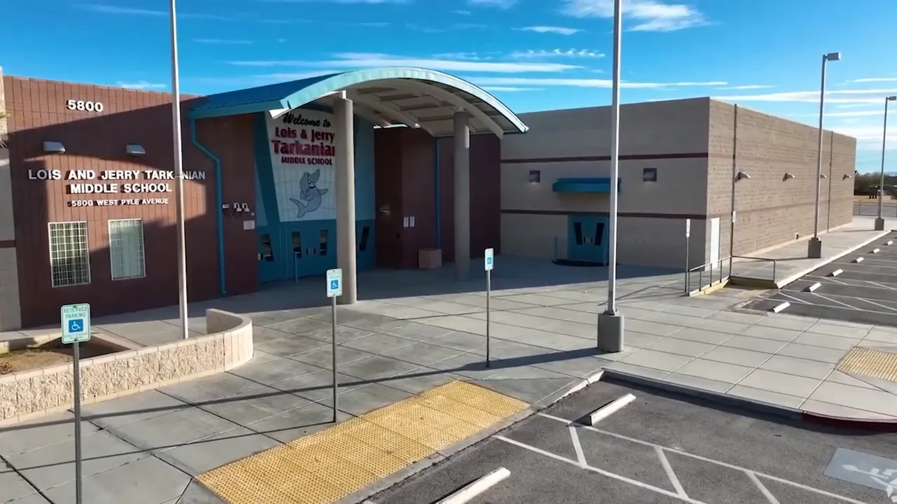 Clear view of a middle school entrance and signage with empty drop-off area and accessible parking spaces.