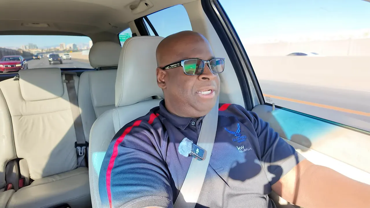 Video host speaking to camera while driving, clear wide shot with no distracting overlays.