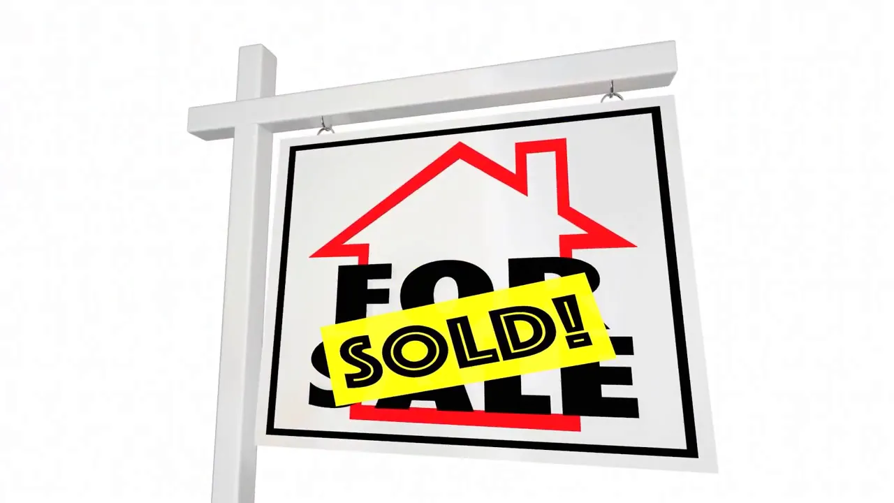 For sale sign with a bright SOLD sticker across it