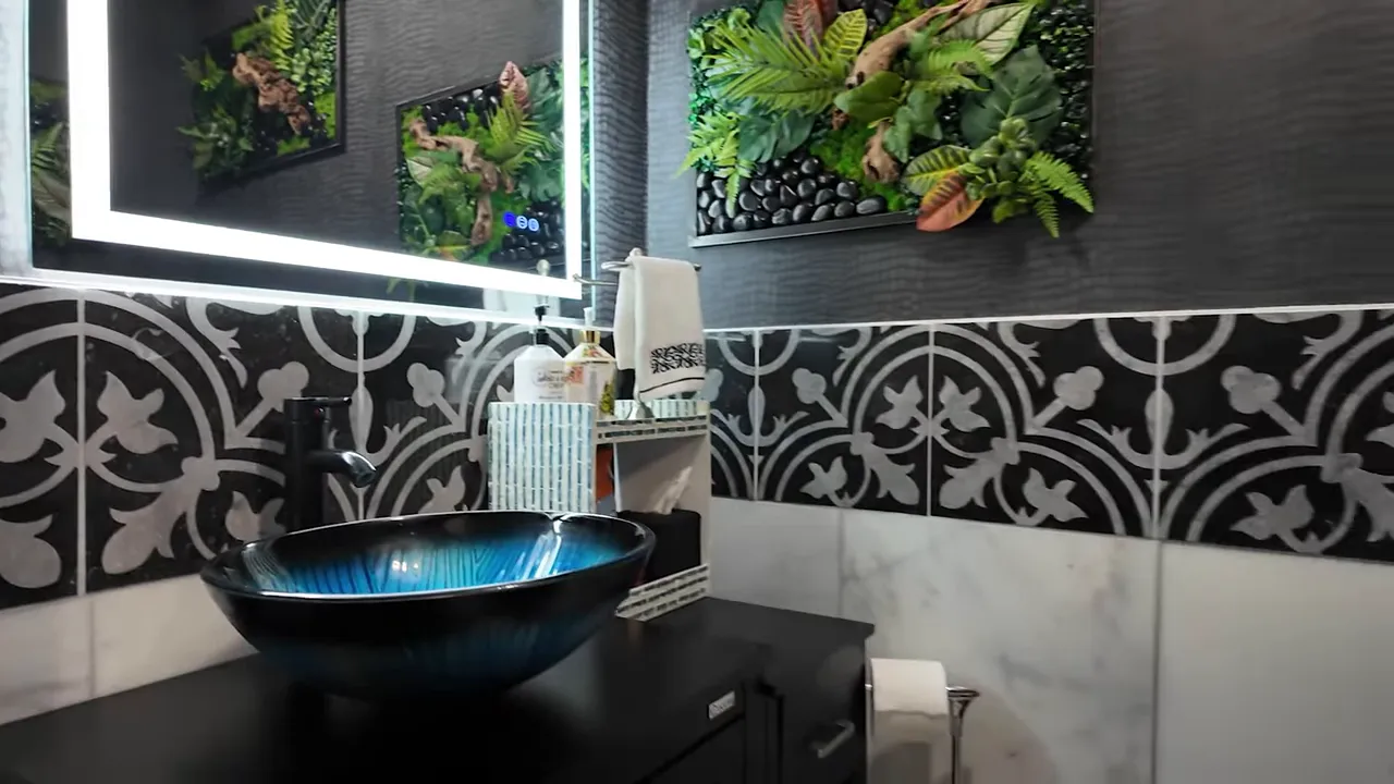 Guest powder room featuring a blue glass vessel sink, patterned tile wainscot and living-art panels