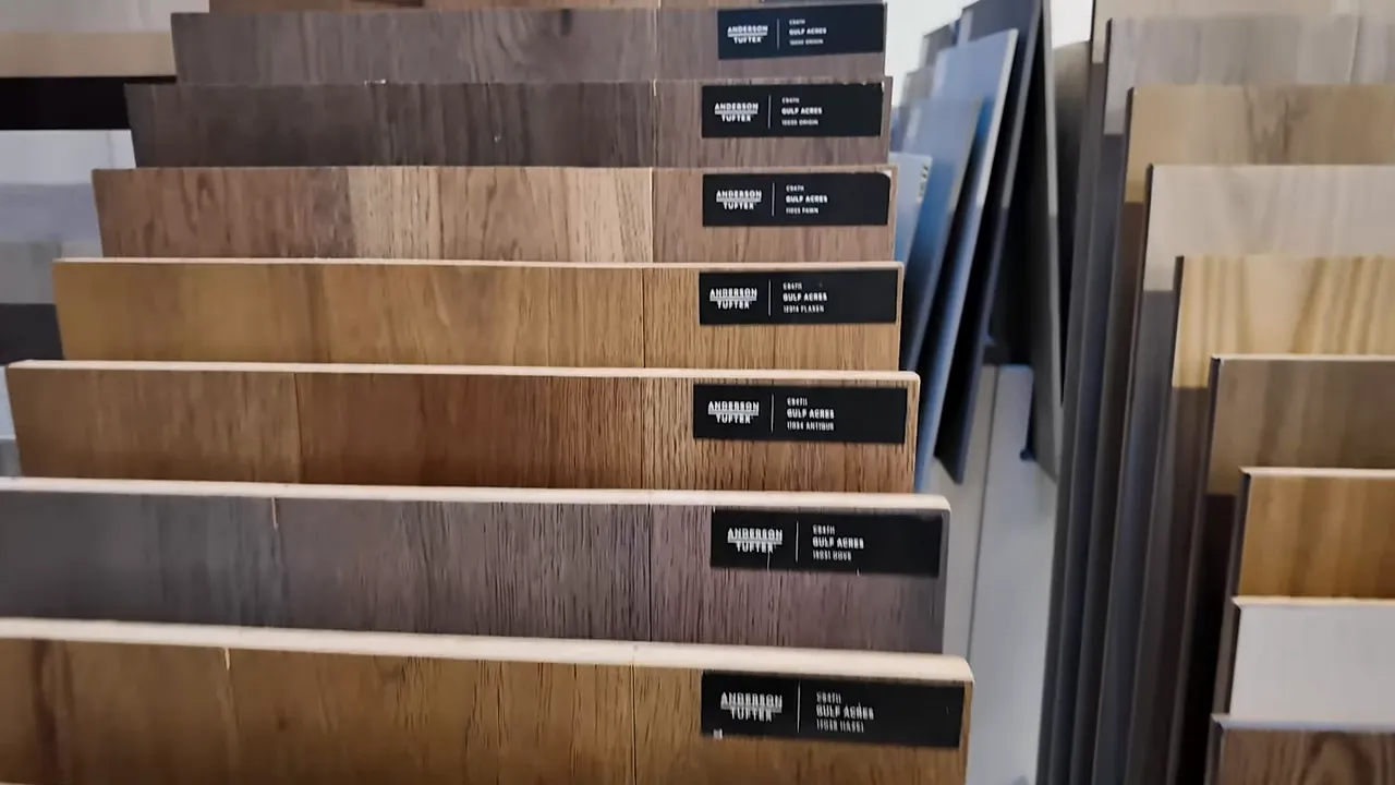 Luxury vinyl plank flooring samples labeled on display shelves at the Richmond American design center