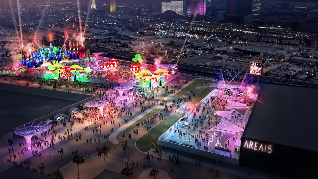 Aerial nighttime view of Area15 outdoor festival with colorful stages, crowds, and visible AREA15 signage.