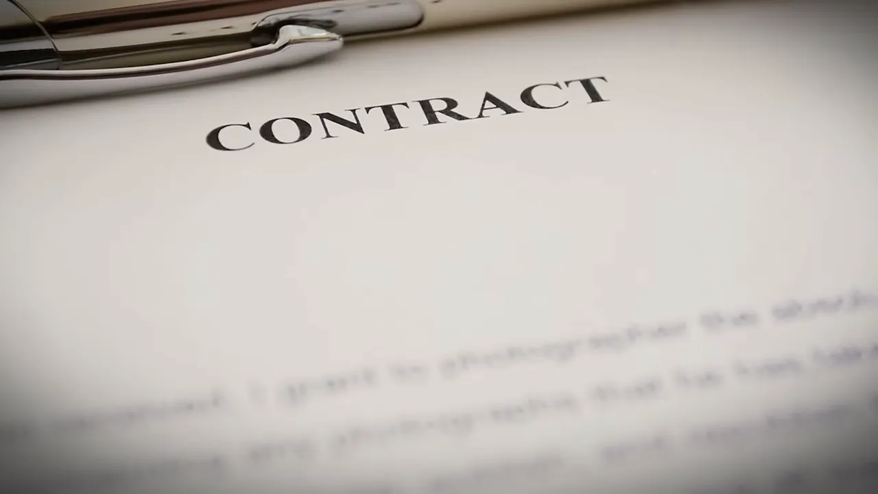 Close-up of a printed contract document with the word 'CONTRACT' visible and a pen