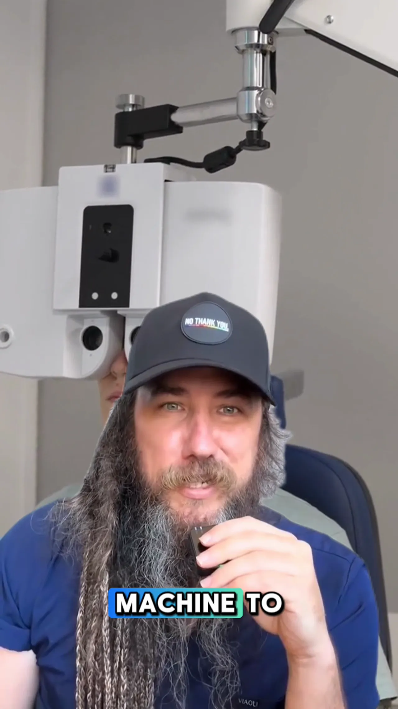 Eye examination machine with a person looking through it and a speaker in front