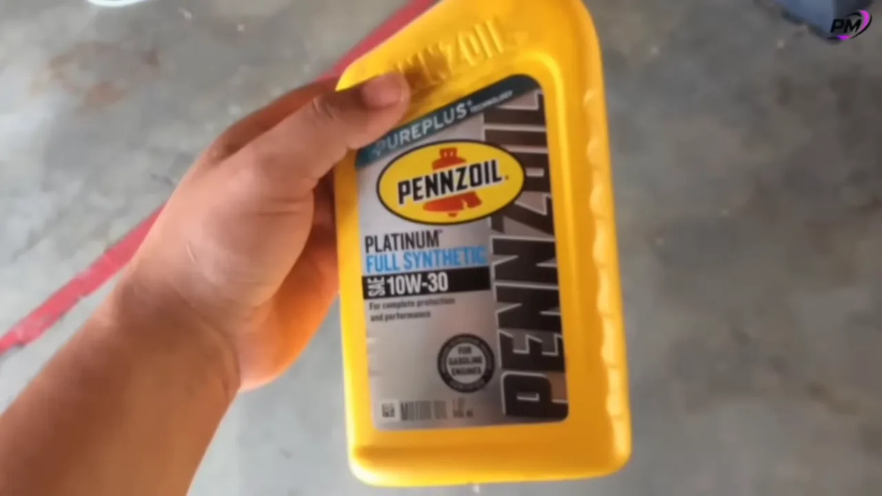 Close-up Pennzoil Platinum full synthetic 10W-30 bottle held in hand