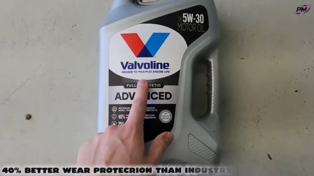 Top-down shot of a Valvoline Advanced full synthetic oil bottle with a finger pointing at the label