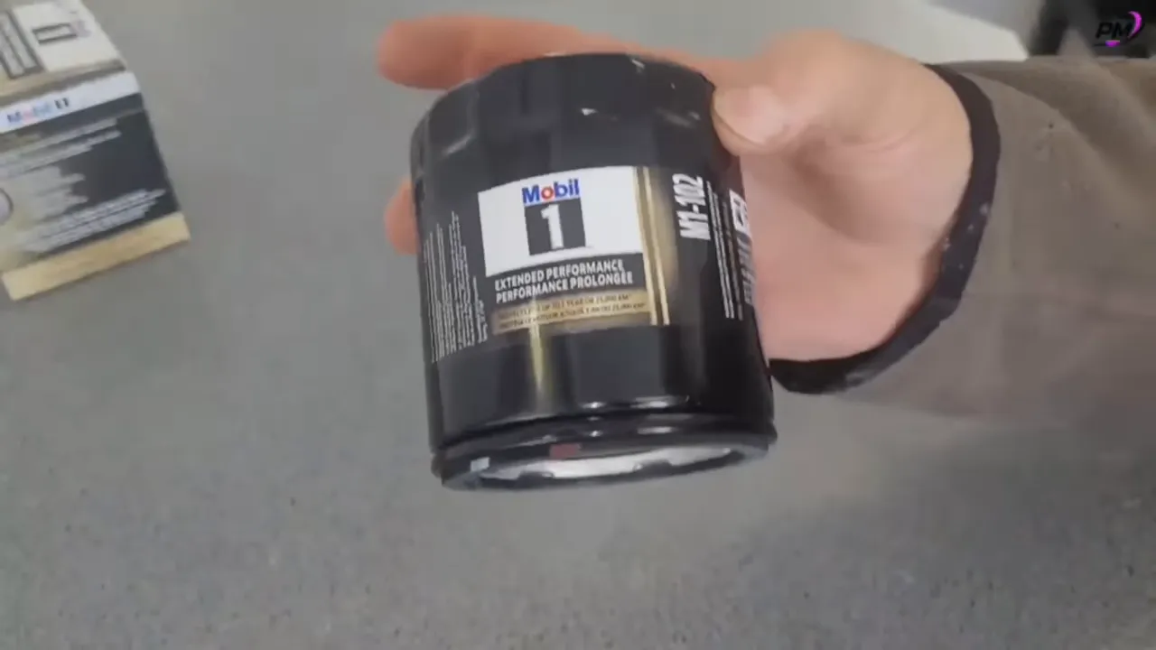 hand holding a black Mobil 1 extended performance oil filter canister with label visible