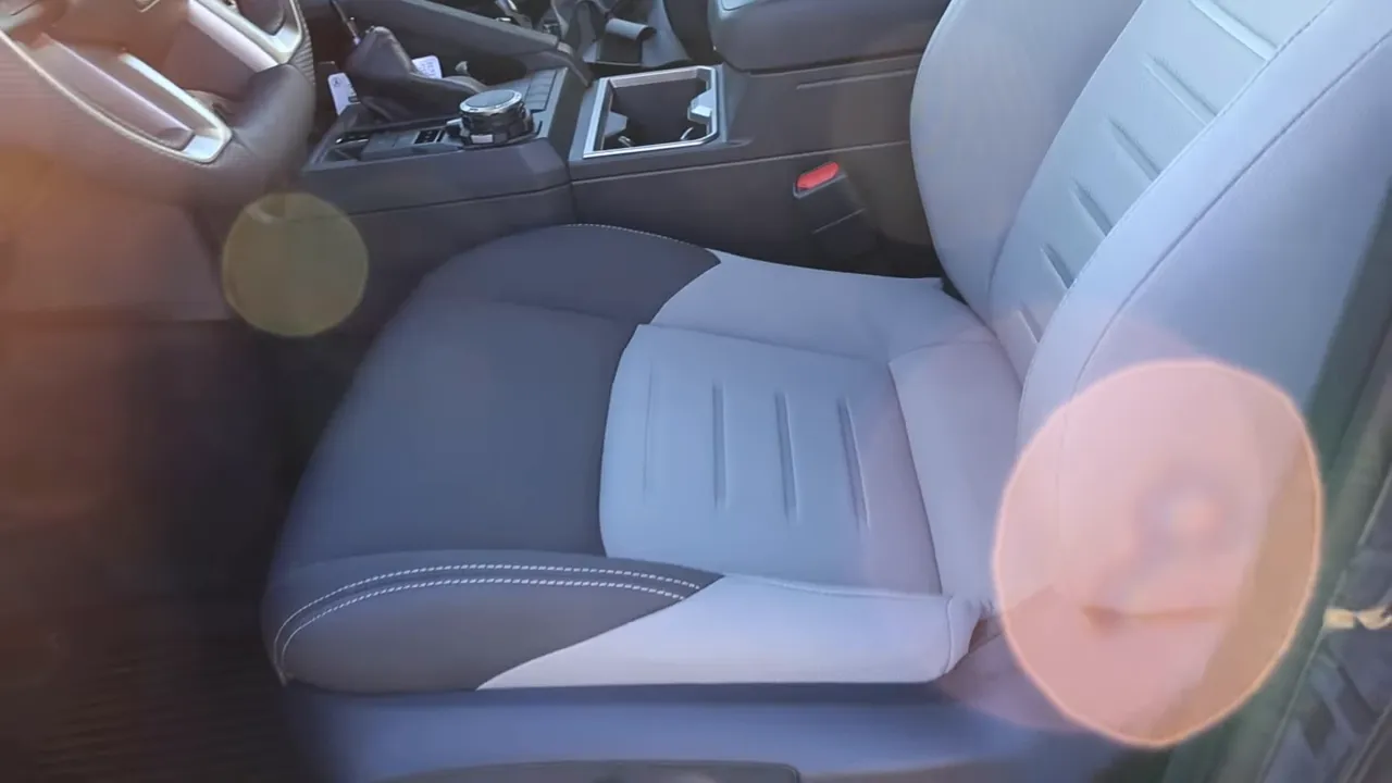 Front interior with center console, shifter, drive-mode selector dial and passenger seat