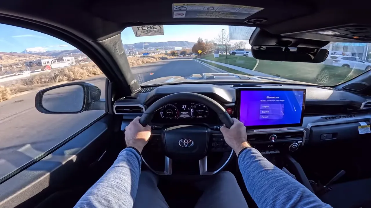Driver POV Toyota Tacoma with hands on wheel, clear instrument cluster and road ahead
