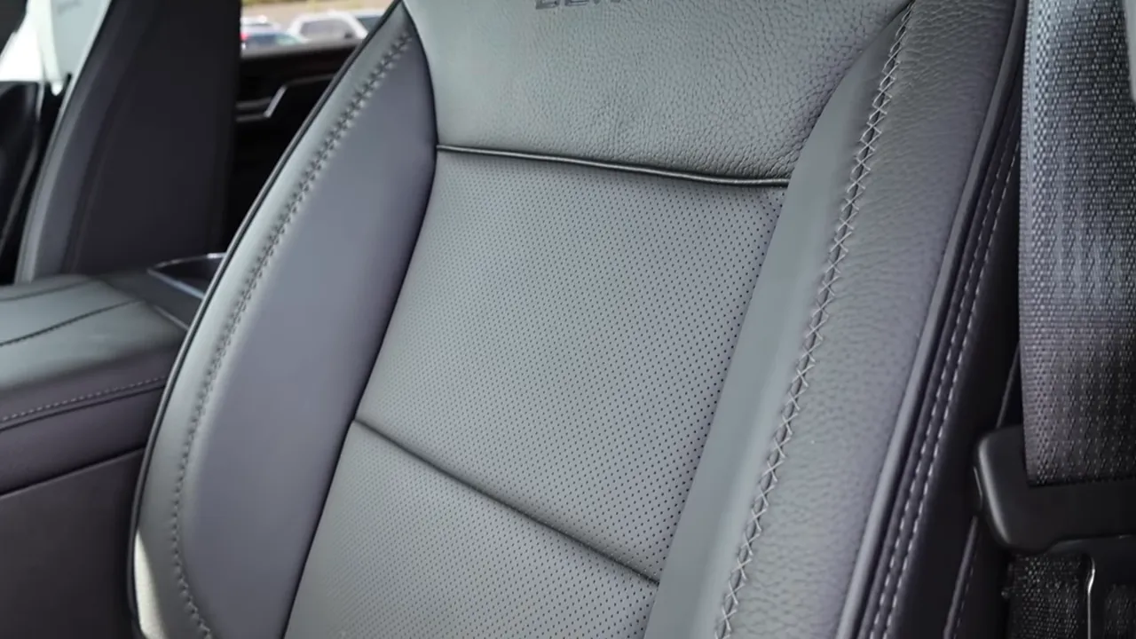 Close-up of GMC Sierra Denali front seat showing perforated leather, contrast stitching and seat texture.