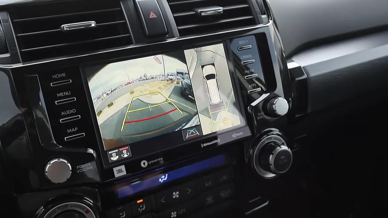 Infotainment screen showing rearview camera and 360-degree surround view with parking guidelines