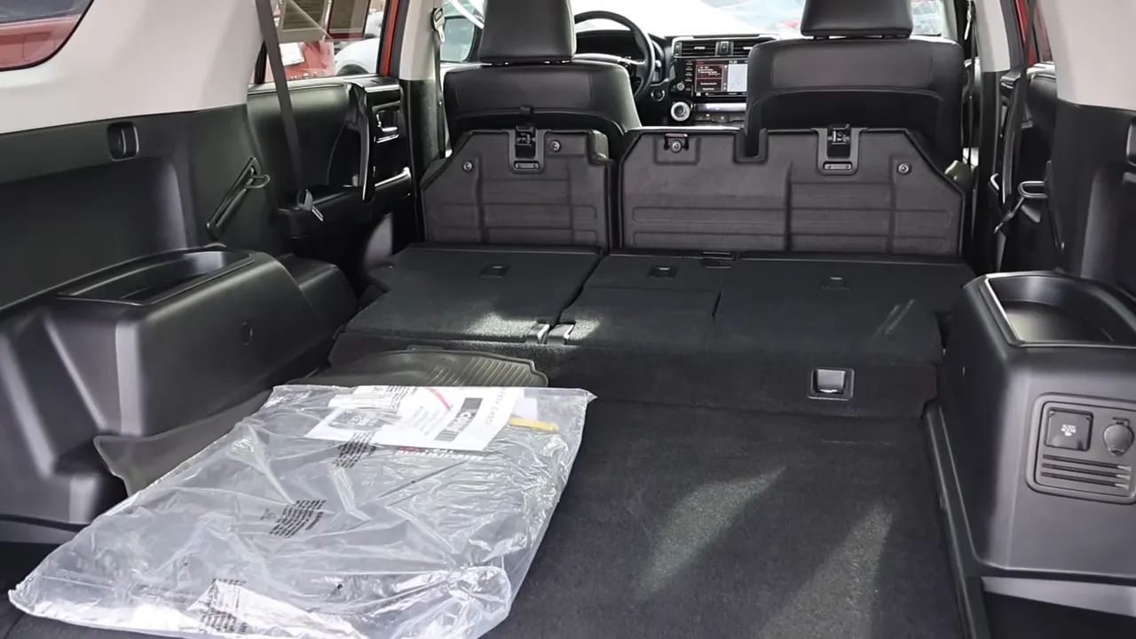 Toyota 4Runner rear cargo area with seats folded flat and packaged mats, showing storage area
